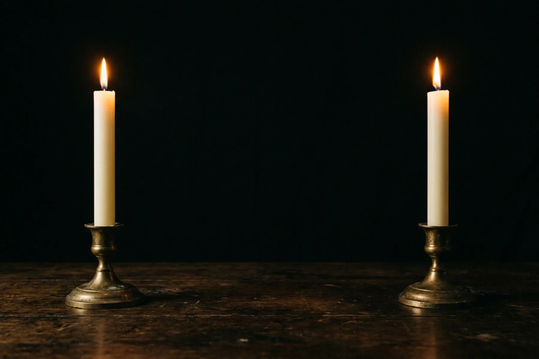 A single white candle burning still in absolute darkness — the held flame as the mind preparing the next sound in the silence between notes