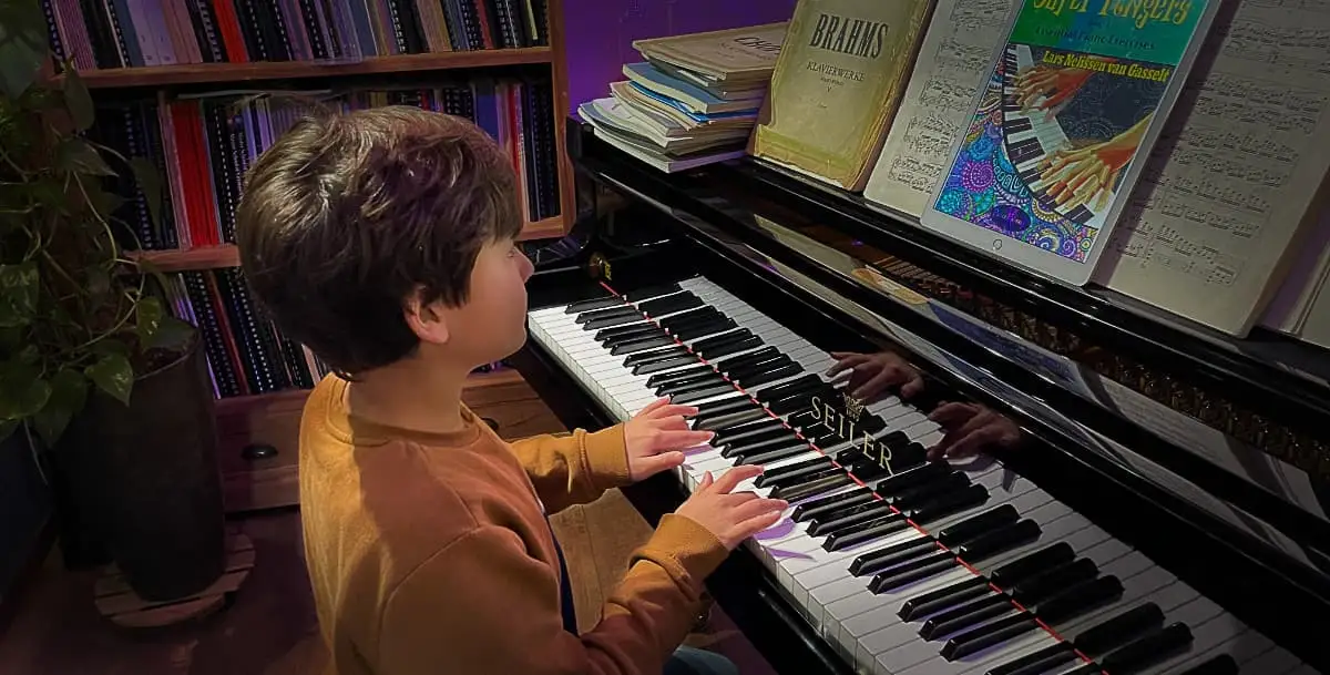 A student practising at the piano using the Super Fingers method — the Super Fingers book is visible on the music desk